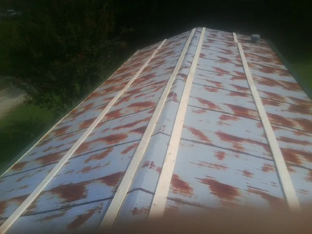 Rusted metal roof panels with new wood purlins before replacement — Storm Damage Roof Repair in Cecilia by Roofing Brothers