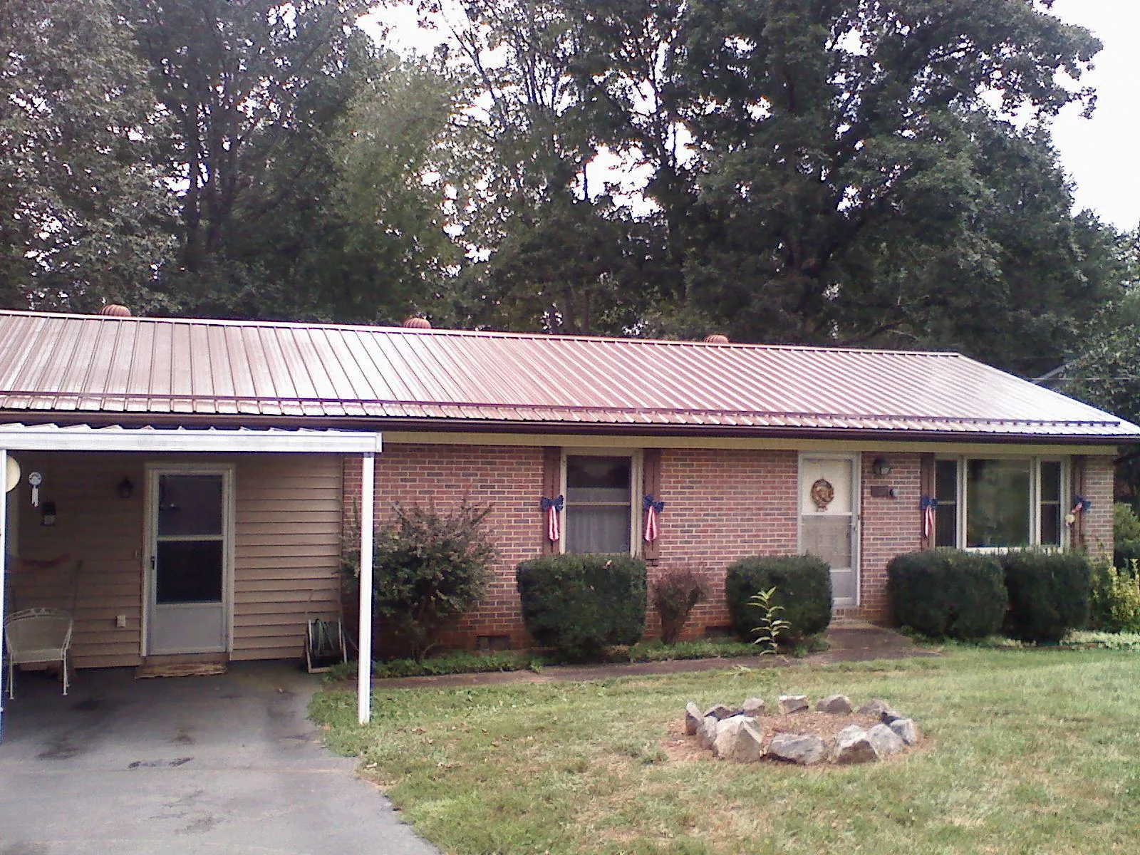 Bronze metal roof and carport on a brick ranch home — Roof Repair work by our crew in Cecilia
