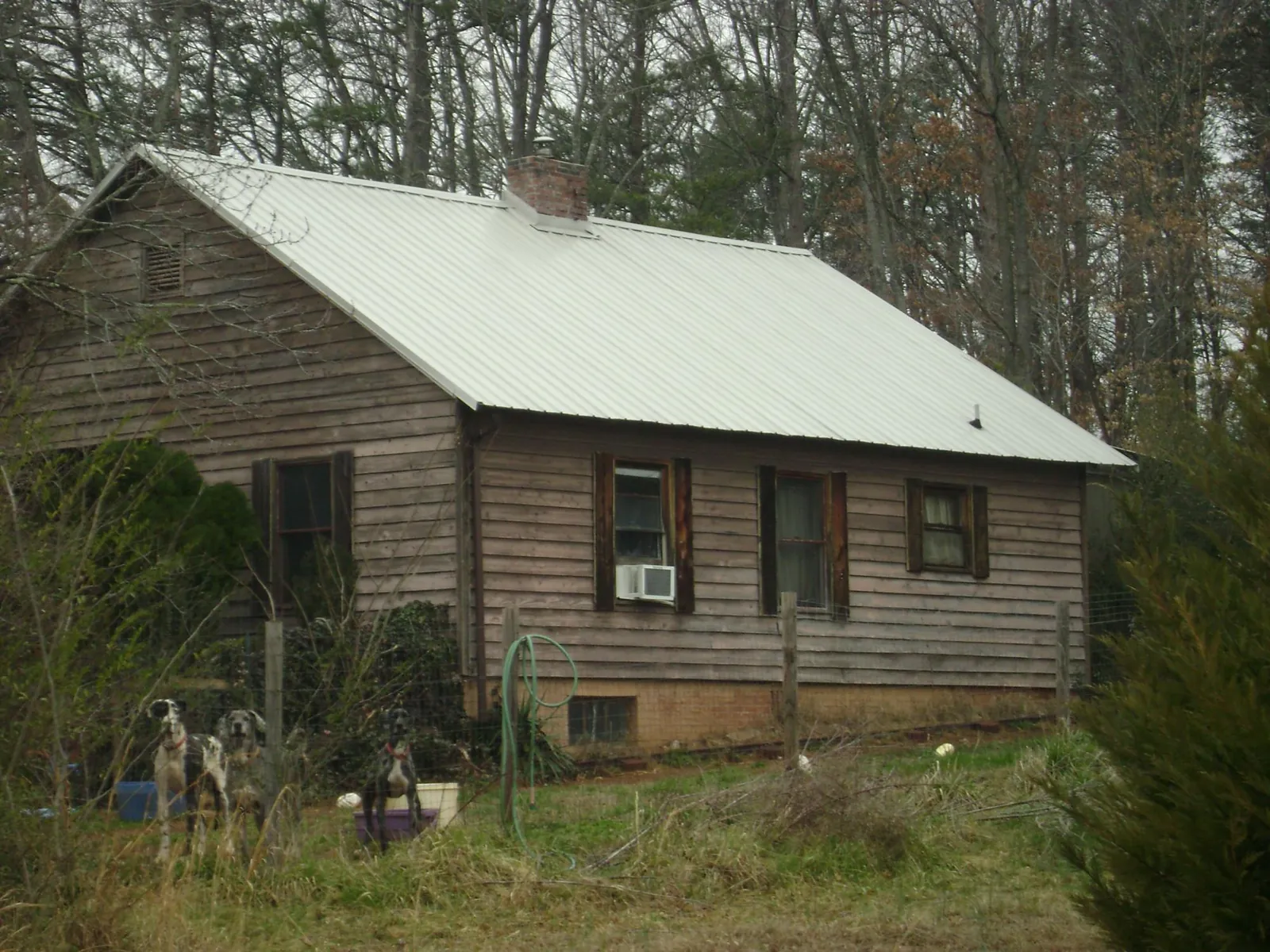 White metal roof on an old wood sided farmhouse, from a Metal Roof Installation job in Cecilia